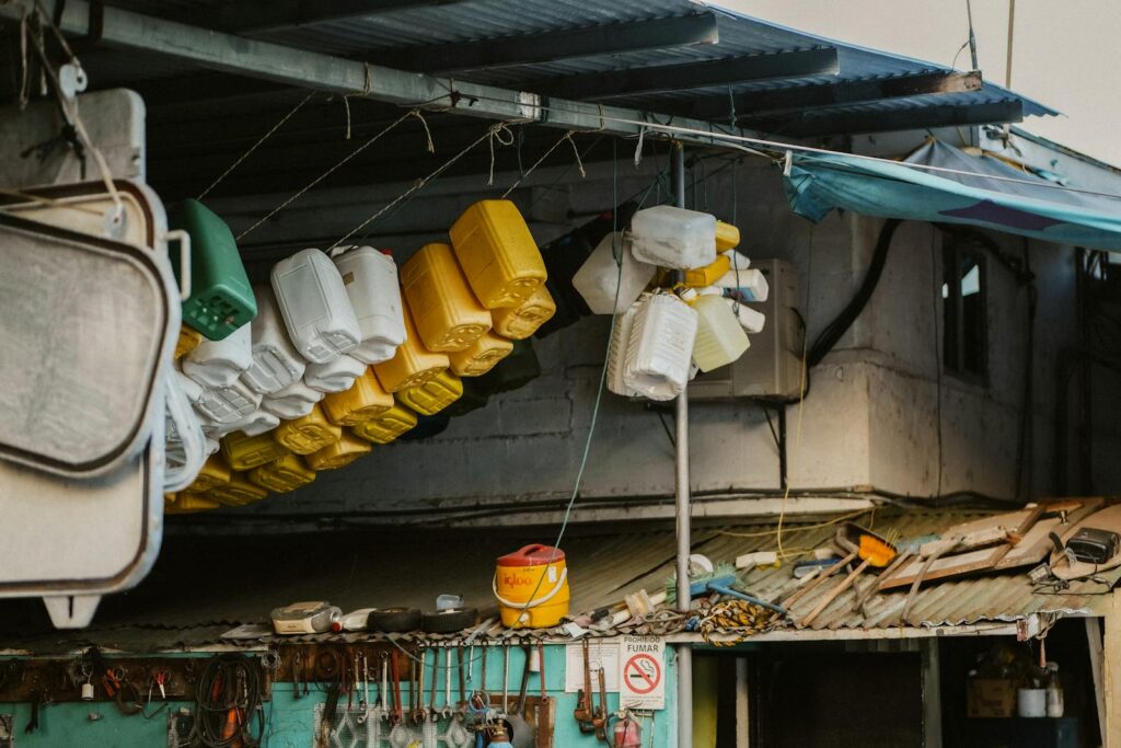 Colorful plastic containers hang in an outdoor market, displaying vibrant urban life.