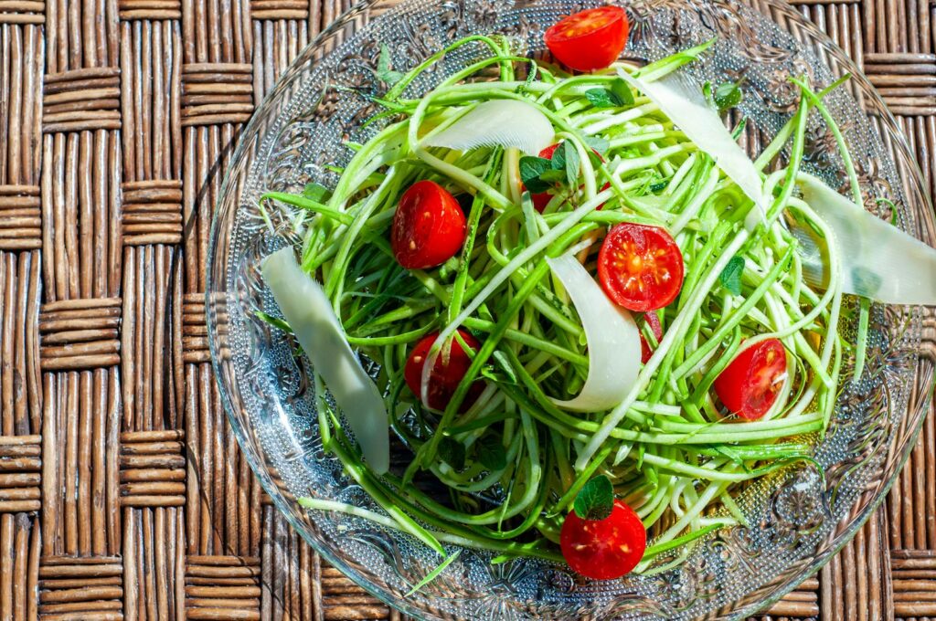 A vibrant zucchini noodle salad with cherry tomatoes and cheese, perfect for a healthy meal.