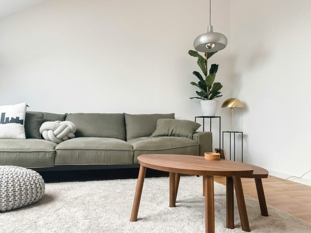 Gray 2 seat sofa near brown wooden coffee table