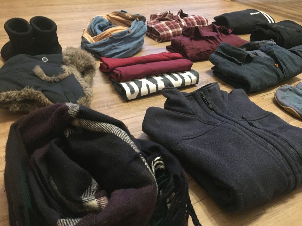 A pile of clothes sitting on top of a wooden floor