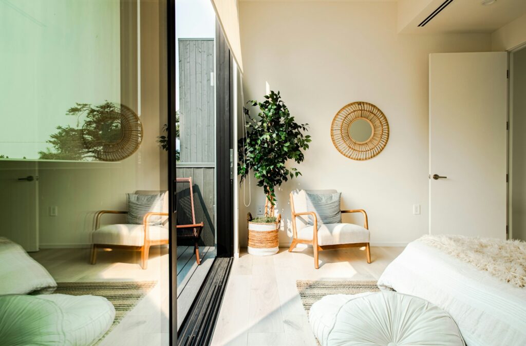White and brown wooden armchair beside white and brown round wall mirror