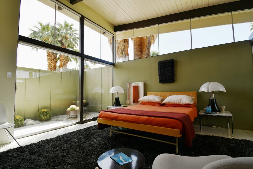 A bed sitting in a bedroom next to a window
