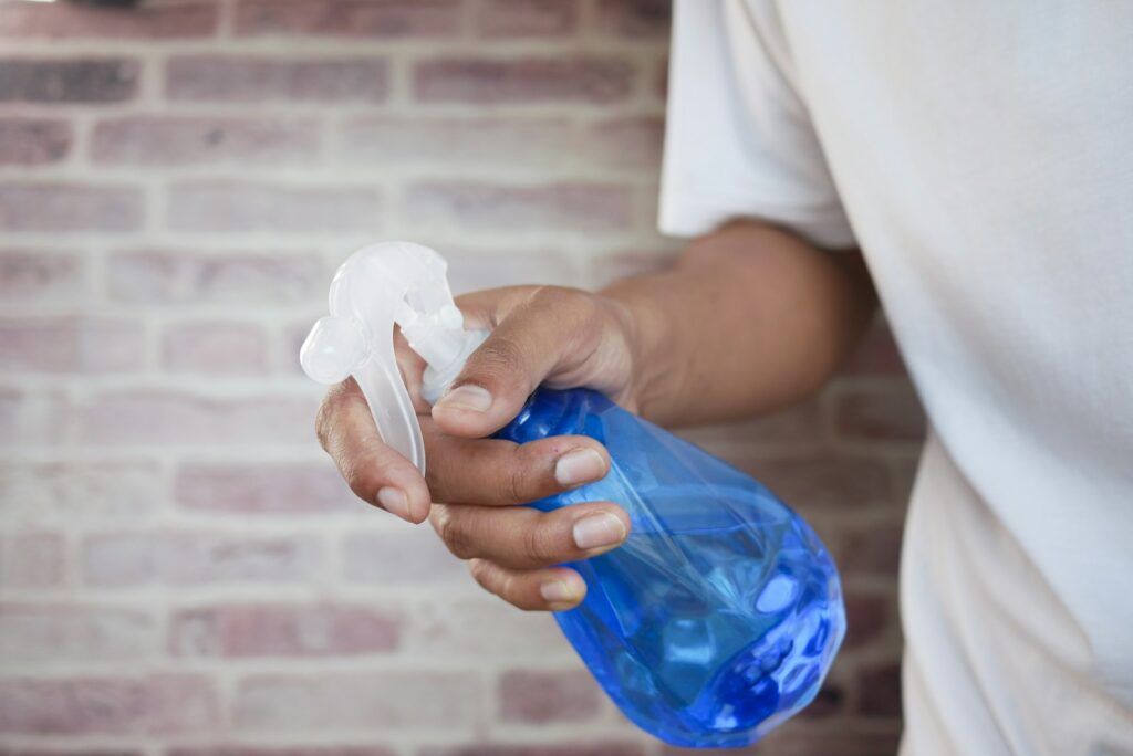 Person in white shirt holding blue plastic bottle