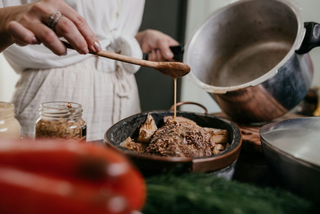 Person holding brown wooden ladle