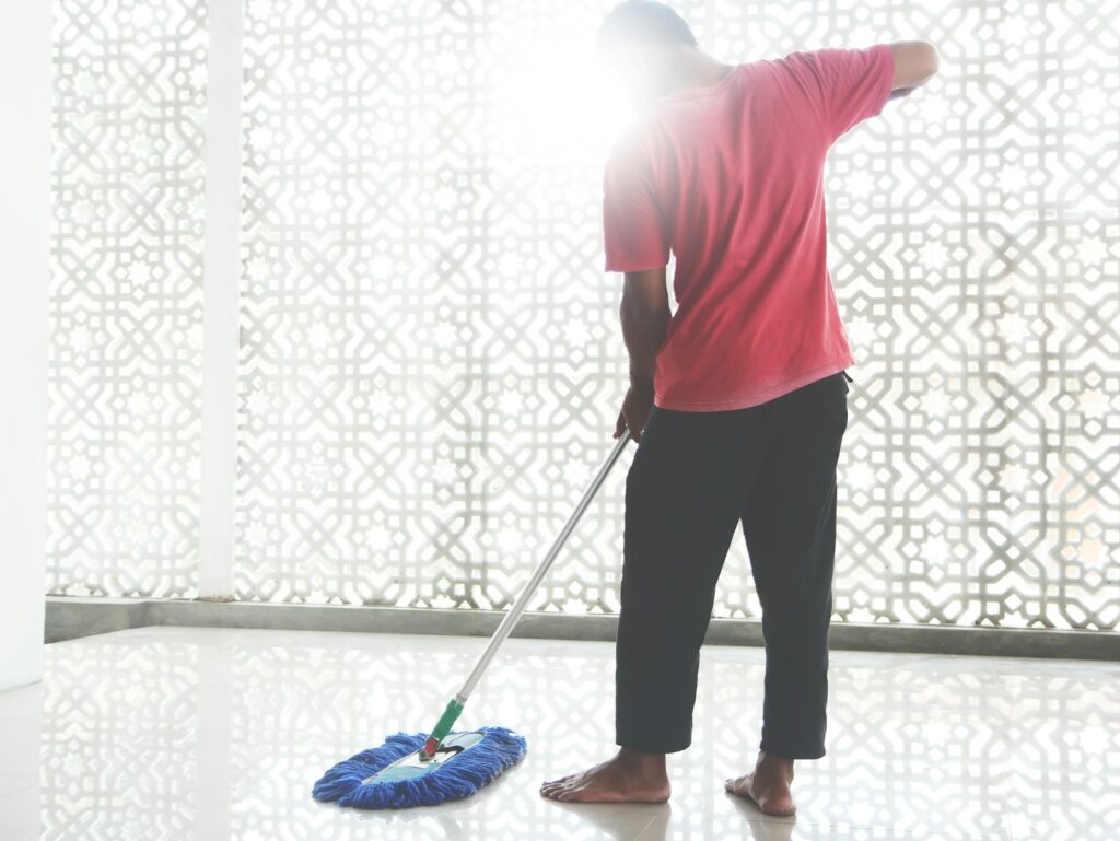 A person with a broom and a bucket