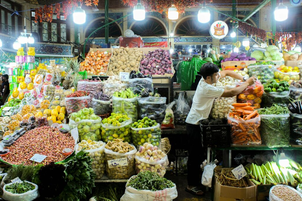 A man standing in front of a display of fruits and vegetables