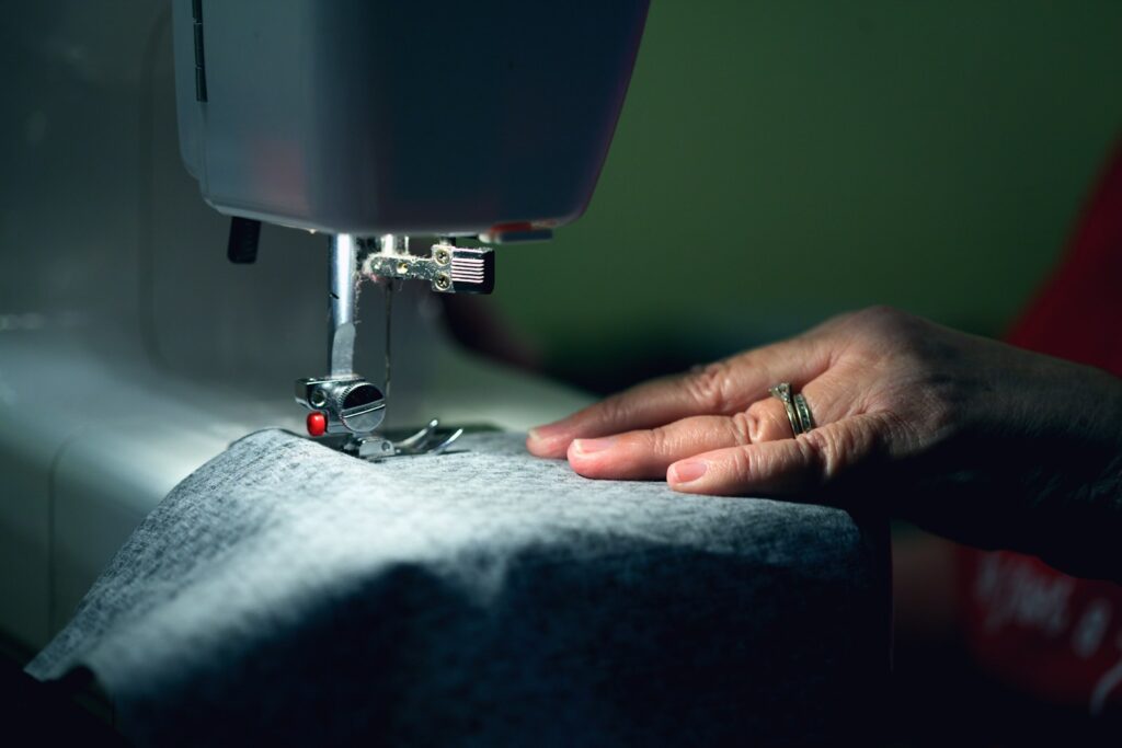 Person in gray shirt sewing