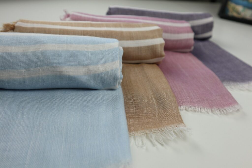 A group of different colors of blankets on a table