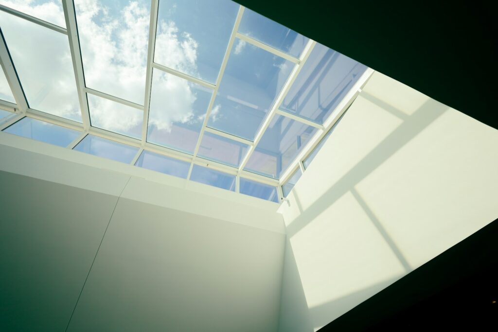 A room with a skylight and a white wall