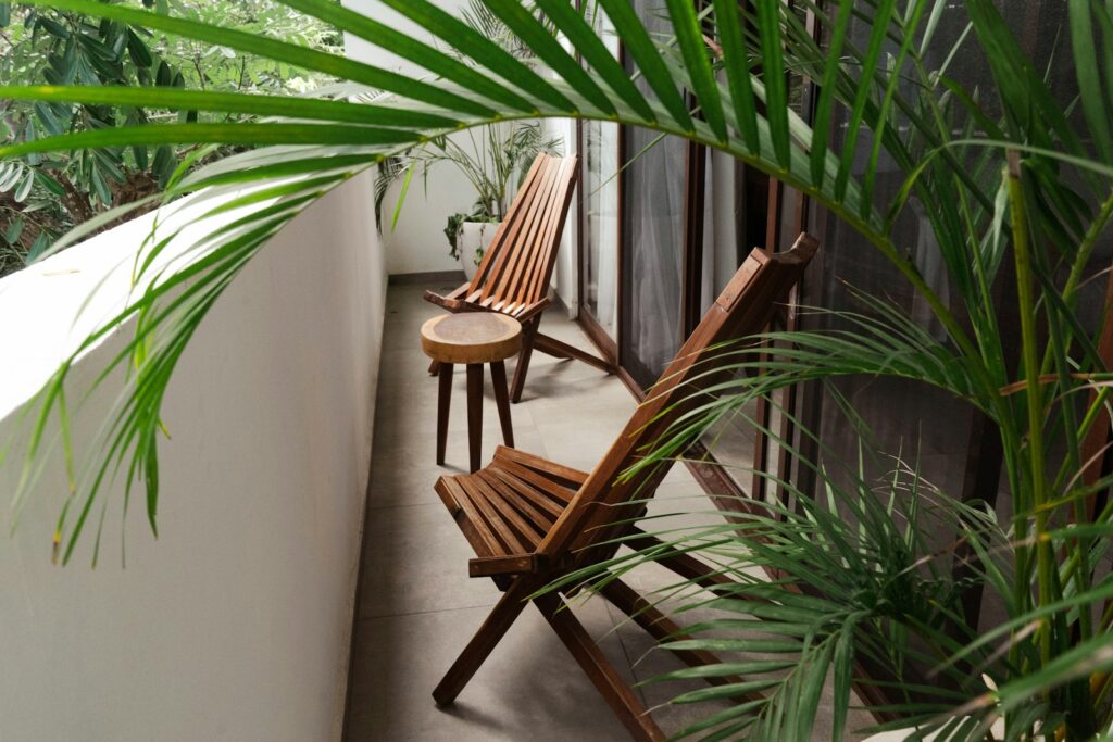 A couple of wooden chairs sitting on top of a balcony