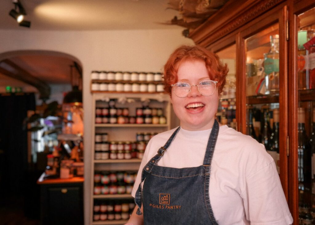 A woman wearing glasses and an apron in a store