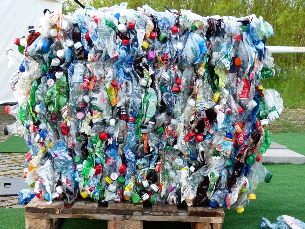 A large stack of plastic bottles neatly arranged on wooden pallets, highlighting recycling efforts and waste management.