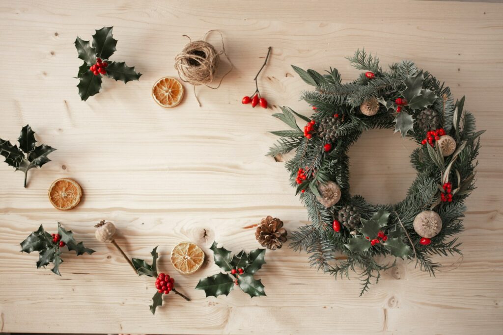 Green and red wreath on white wooden wall