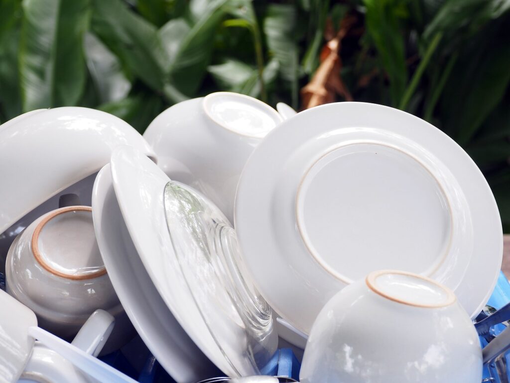 A collection of white dishes and cups piled together on a table, showcasing a simple and elegant dining setup.