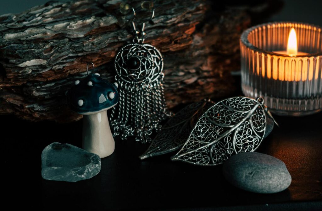 A cozy still life arrangement featuring candlelight, metalwork decor, and natural elements.