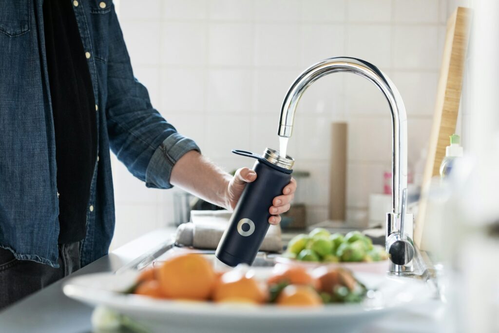 Person holding stainless water bottle.
