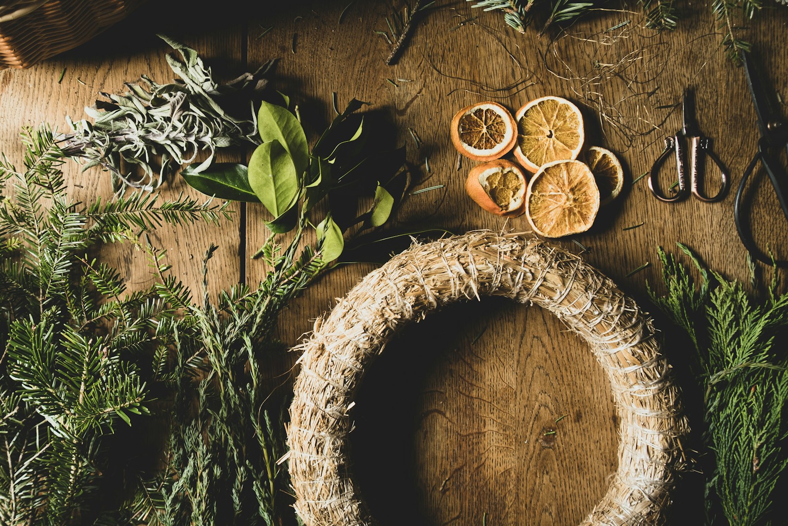 A wooden table topped with oranges and herbs