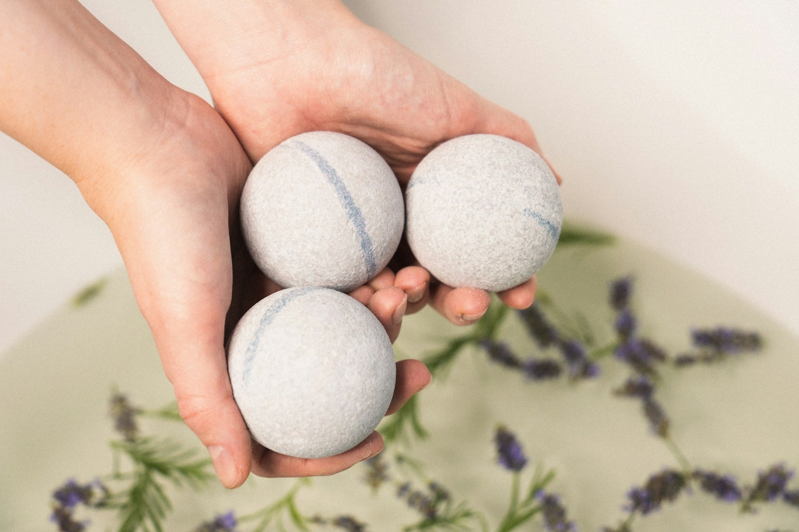 A person holding three balls in their hands