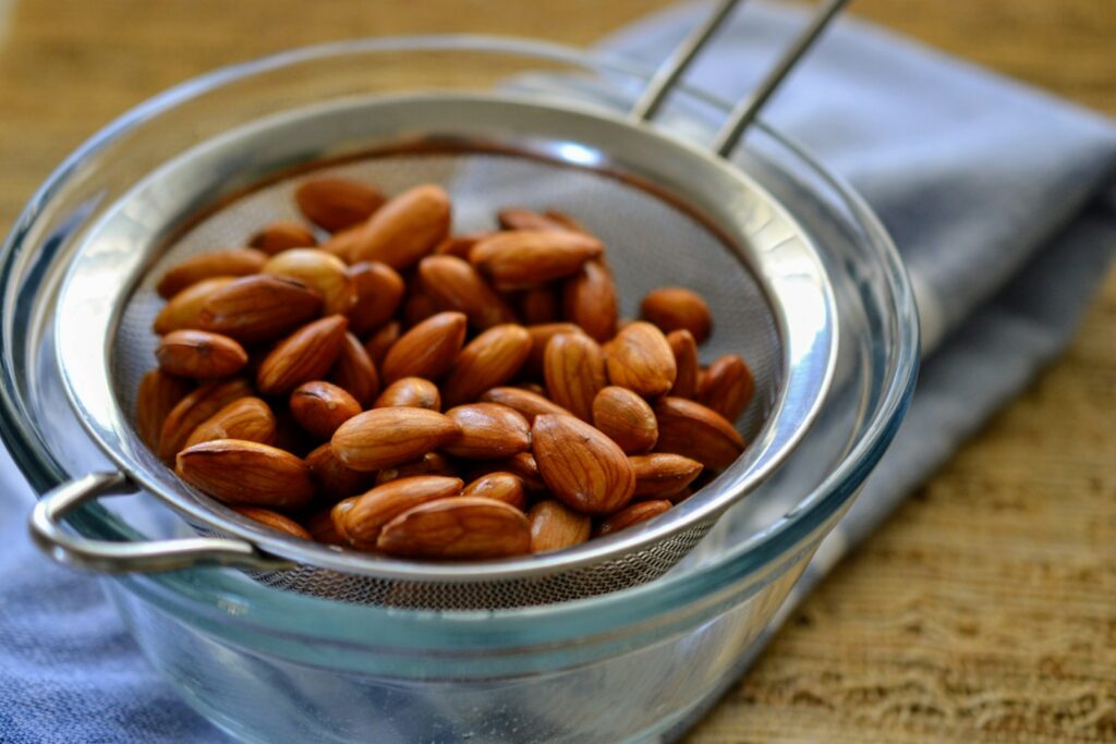A bowl filled with almonds sitting on top of a table