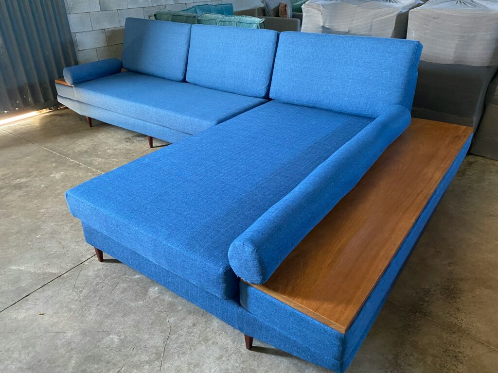 A blue couch sitting on top of a wooden table.