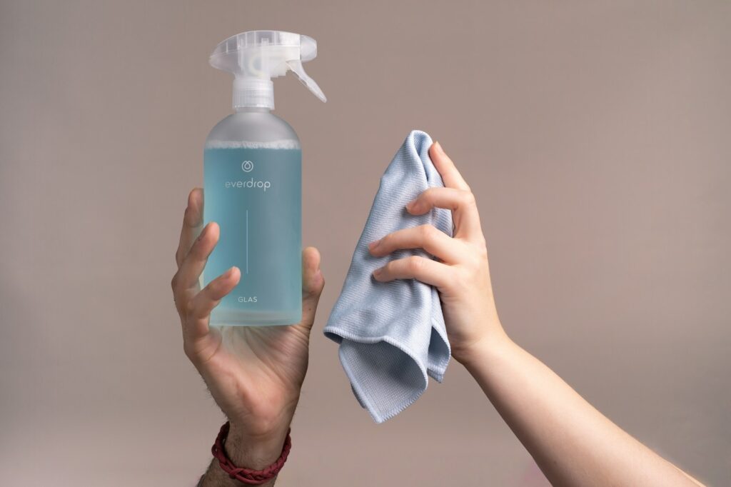 A person holding a bottle and wipes.