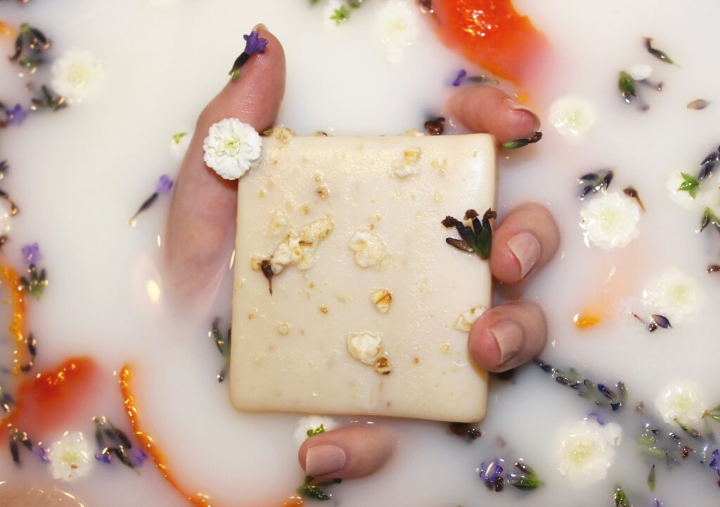A hand holding a piece of cheese