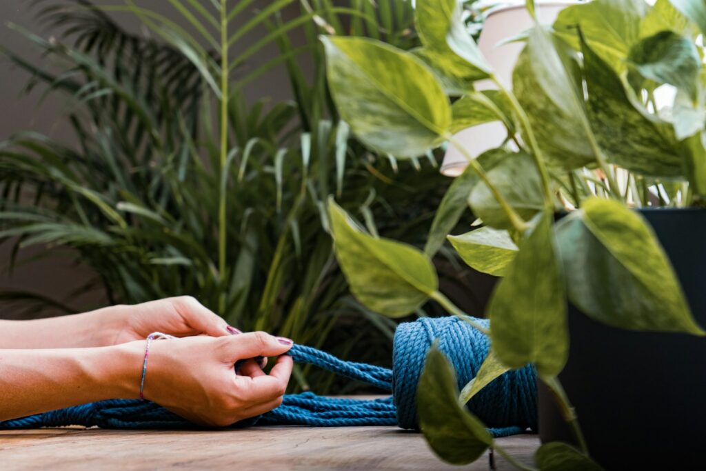 A person tying a blue rope on a table
