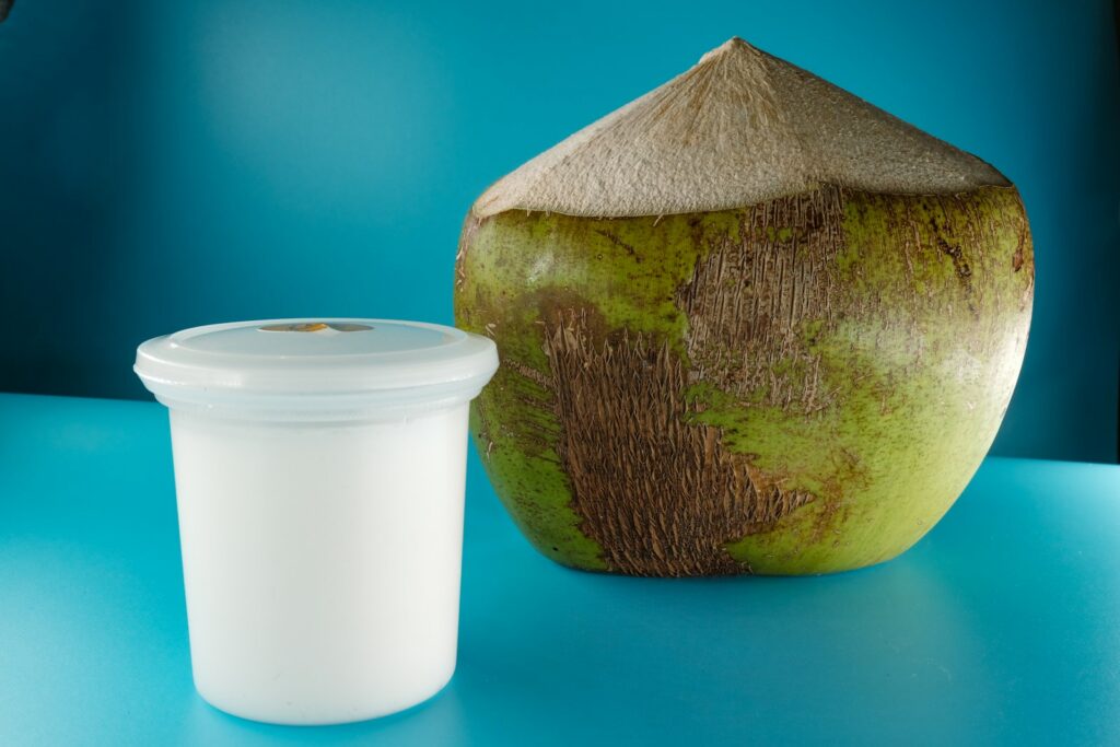 Coconut milk beside a coconut shell.