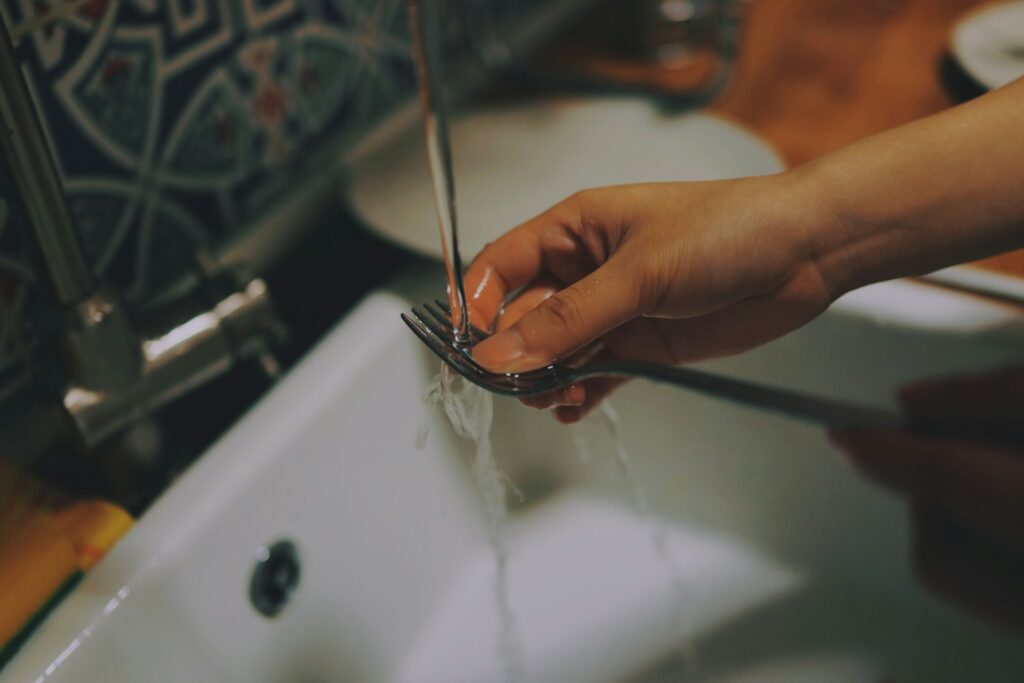 Person washing utensils.