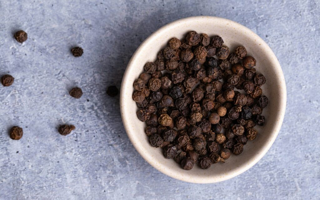 Black pepper on white ceramic bowl.