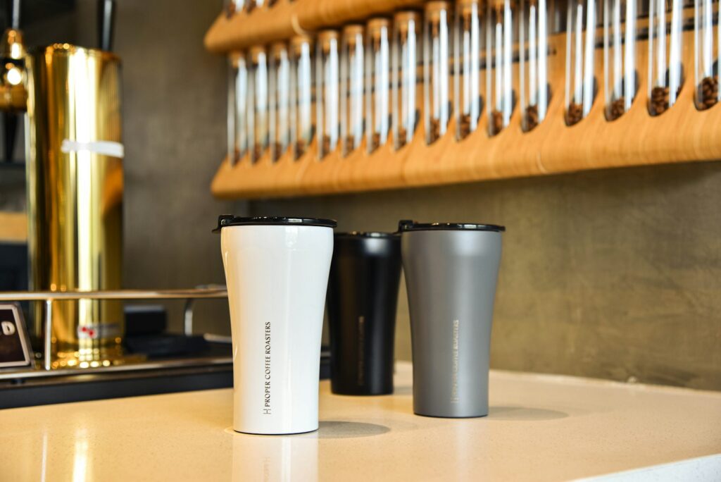 A counter top with reusable cups on it.