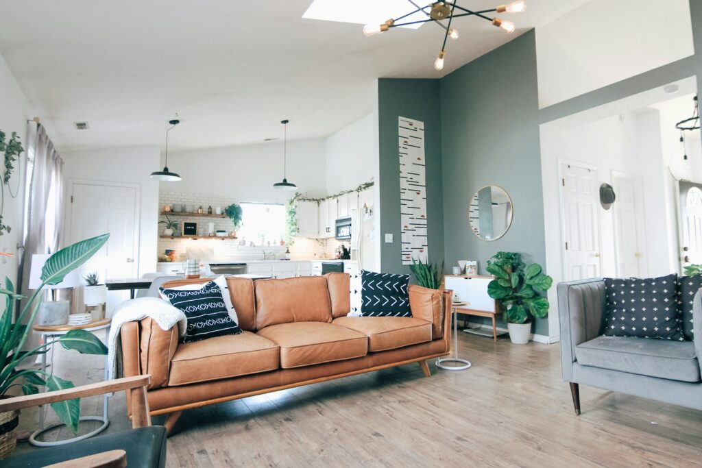 A bright living room with a comfortable couch, a modern coffee table, and lush plants adding a touch of nature to the space.