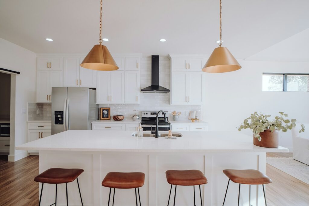 A kitchen with three stools and a center island.