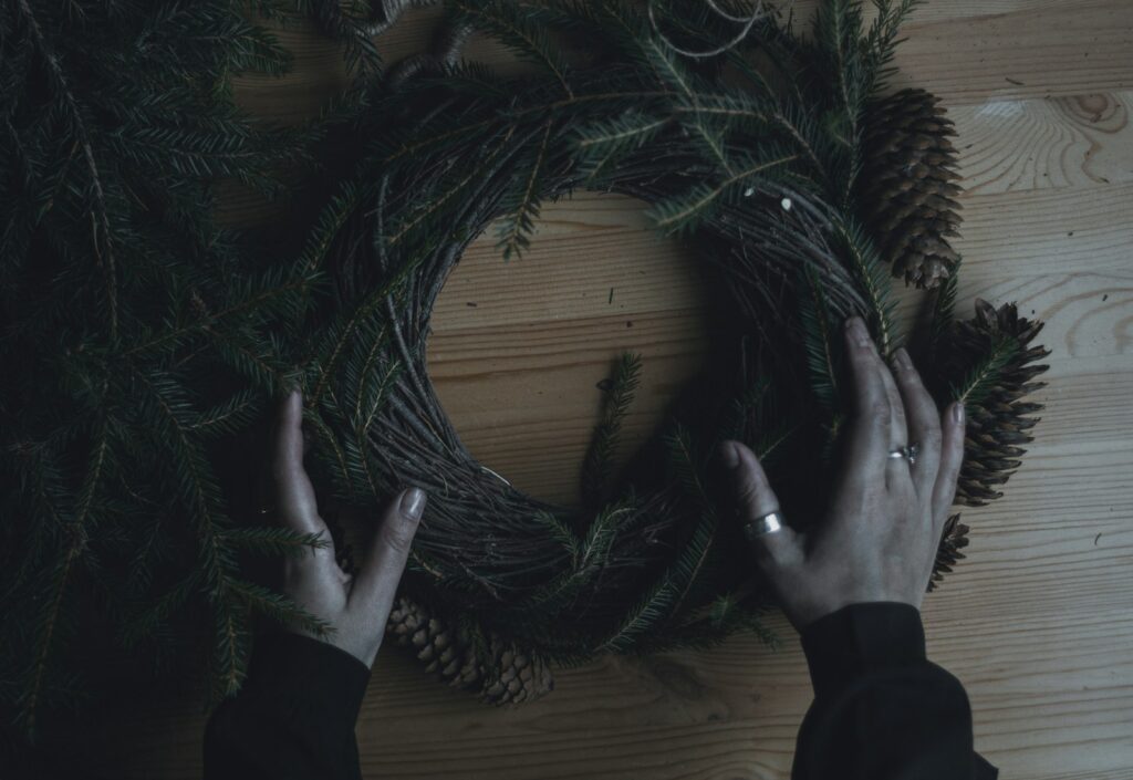 A person holding a wreath on top of a wooden table
