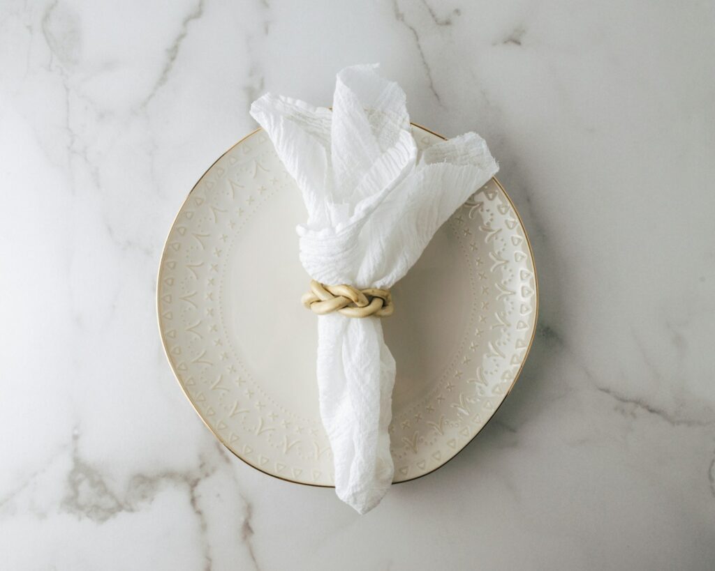 White cloth napkin on a white round plate.