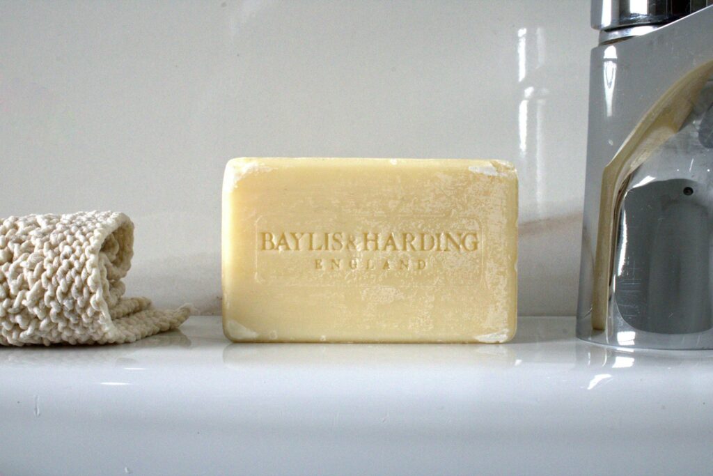A bar of soap next to a soap dispenser