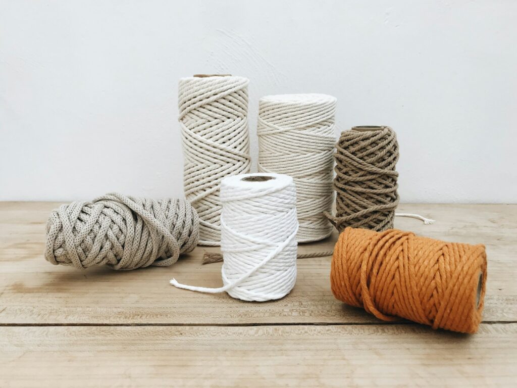 A group of different colored twine on a wooden table