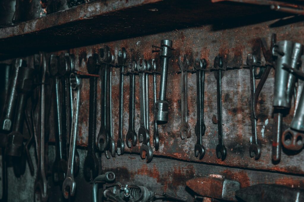 Black metal tools on brown wooden shelf