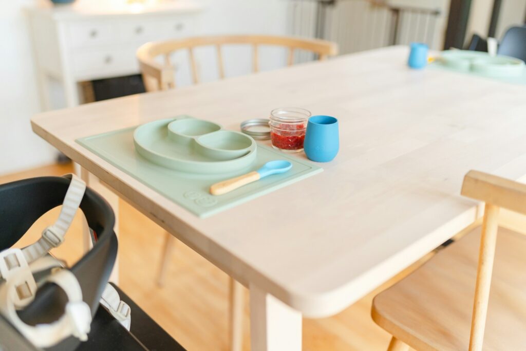 A table with a bowl, plate, and spoon on it.