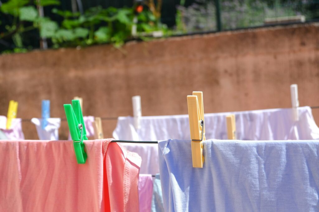 Pink and white textiles hanged on brown wooden clothes hanger.