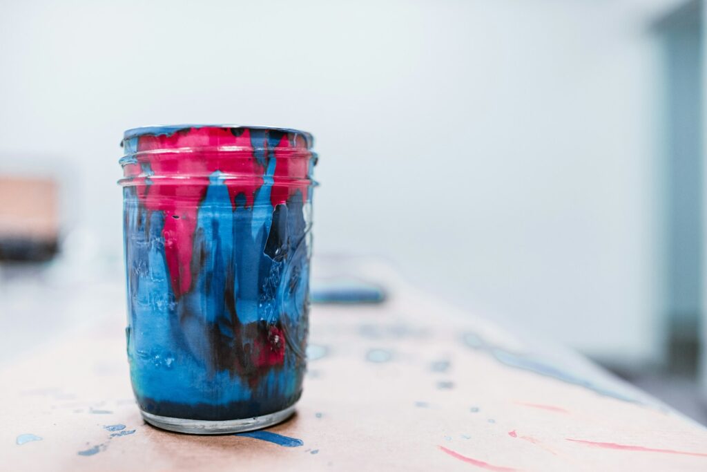 Blue and red paint jar on white surace