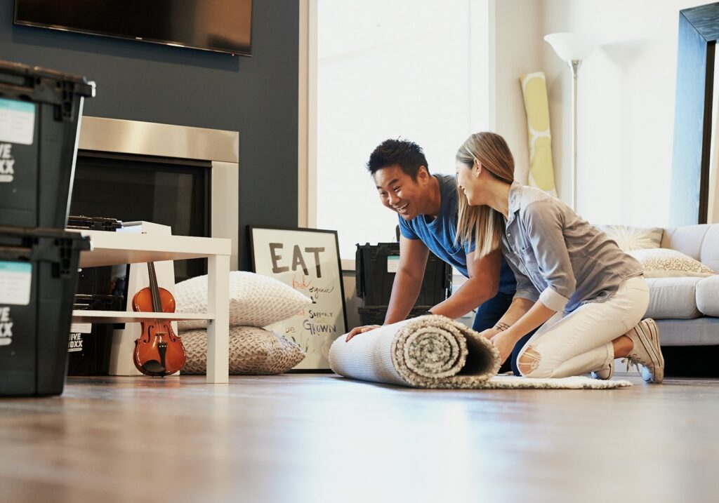 Man in blue t-shirt sitting on floor.