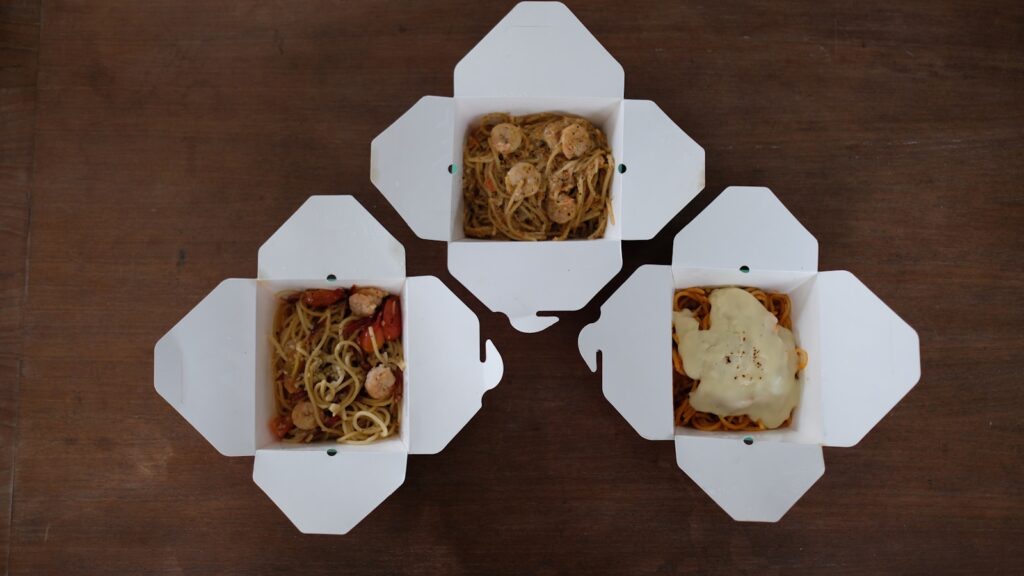 Four boxes of food are arranged on a table.