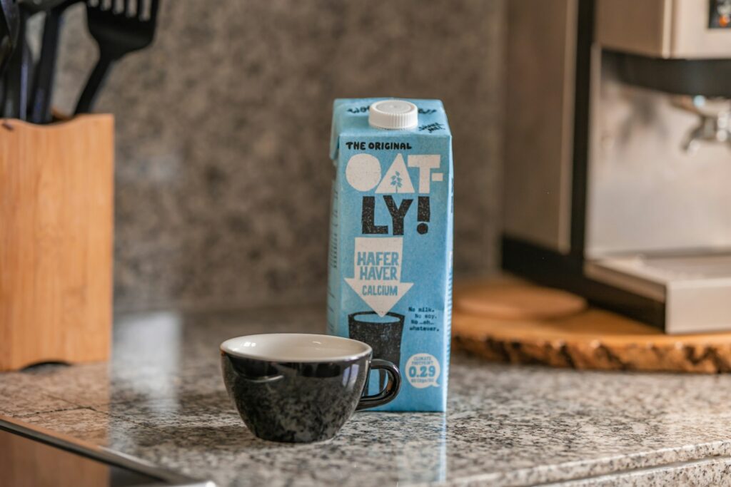 Blue and white oat milk carton box on gray marble table.